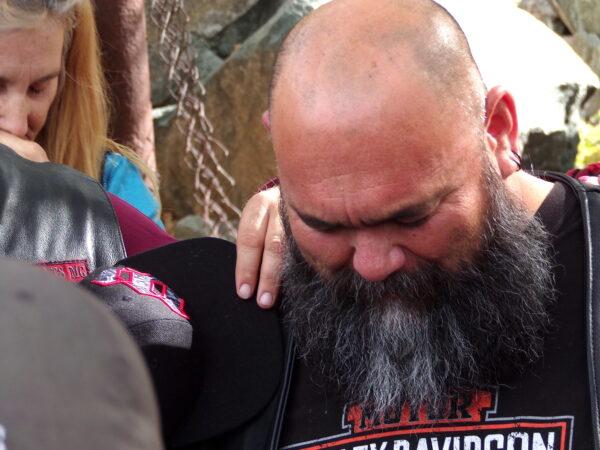 A member of the Ascendants Motorcycle Club bows his head in prayer at a family gathering in Jerome, Ariz., on Oct. 15, 2022. (Allan Stein/The Epoch Times)
