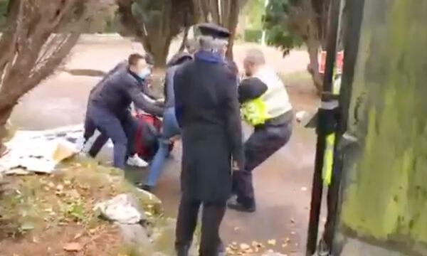 Screenshot from video showing a police officer trying to rescue a Hong Kong protester who was being beaten at the Chinese consulate in Manchester, England, on Oct. 16, 2022. (Screenshot/Hong Kong Indigenous Defence Force via The Epoch Times)