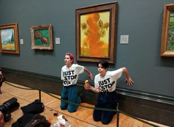 JSO activists glue their hands to the wall after throwing soup at Vincent van Gogh's 'Sunflowers' at the National Gallery in London, England, on Oct. 14, 2022. (Just Stop Oil/Handout via Reuters)