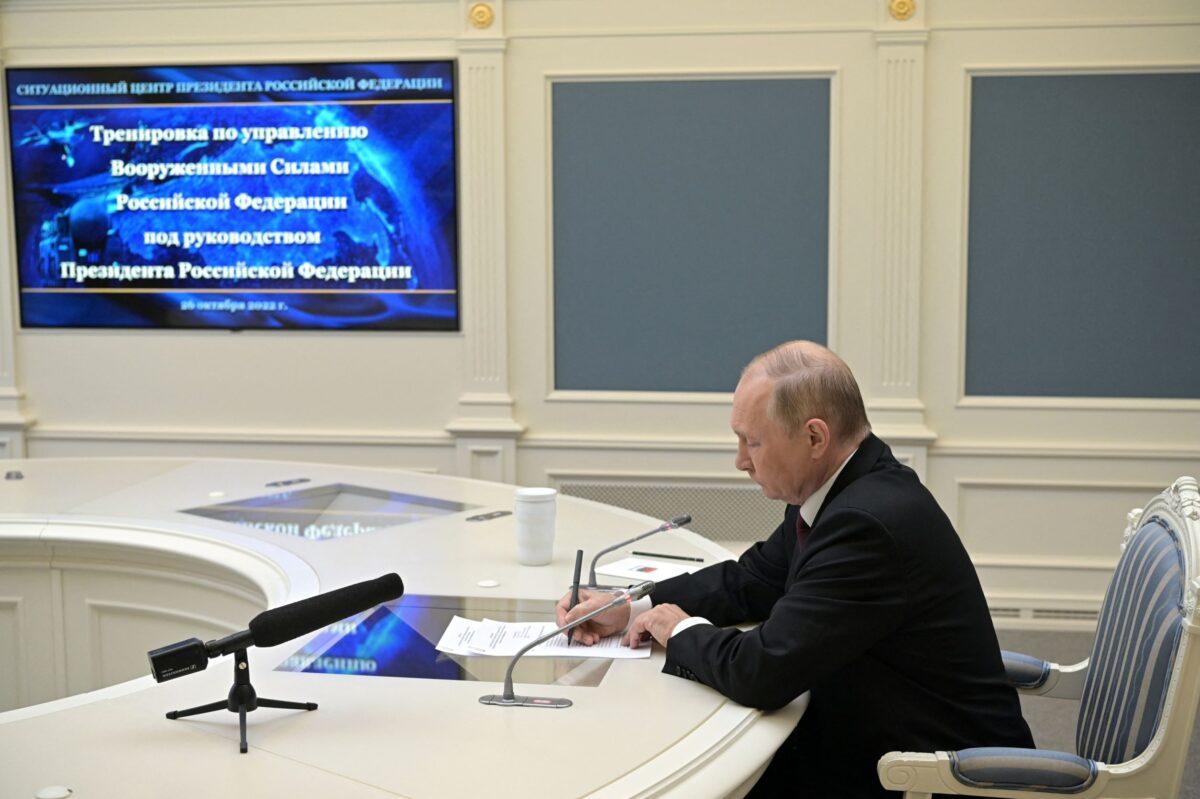 Russian President Vladimir Putin writes notes as he observes exercises held by Russia's strategic nuclear forces, as he takes part in a video link in Moscow on Oct. 26, 2022. (Alexei Babushkin/Sputnik/Kremlin via Reuters)