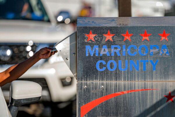 Voters drop their ballots in a dropbox in the U.S. midterm election at the Maricopa County Tabulation and Election Center, in Phoenix, Ariz., on Nov. 8, 2022. (Olivier Touron/AFP via Getty Images)