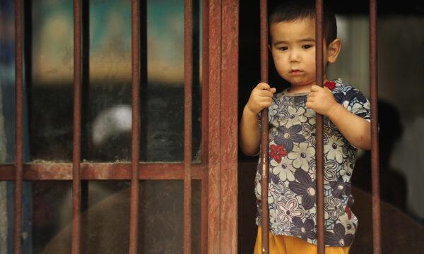 A young ethnic Uyghur boy looks out from his home in the Uyghur area in the city of Urumqi in China's Xinjiang region on July 12, 2009. (Peter Parks/AFP via Getty Images)