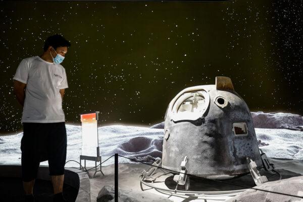 A visitor looks at the model of the lunar landing return capsule during Explore CASCI (China Aerospace Science and Cultural Innovation) ART Exhibition in Wuhan, China, on Oct. 2, 2022. (Getty Images)