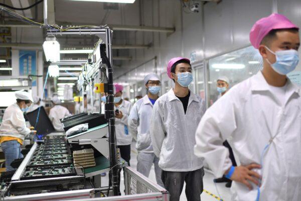 Workers line up to get tested for COVID-19 at the Foxconn factory in Wuhan in central China's Hubei province on Aug. 5, 2021. (Chinatopix via AP)