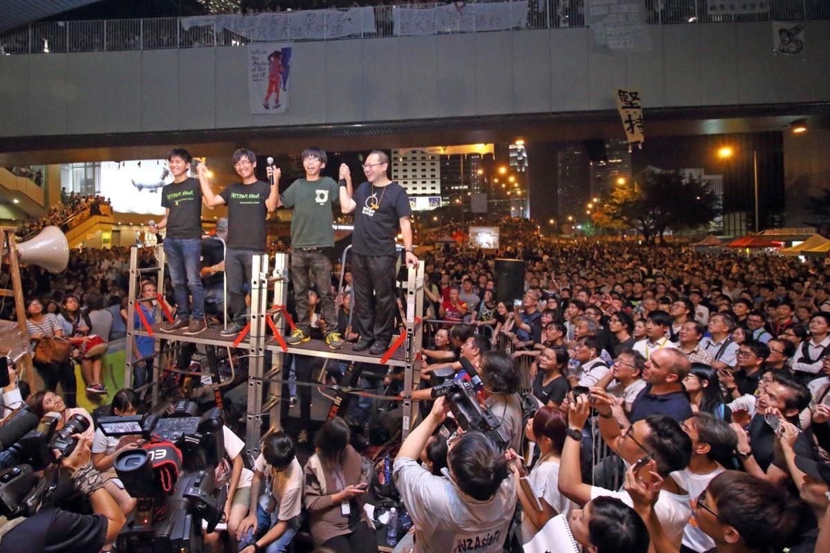 The Hong Kong government canceled a dialogue meeting with the Hong Kong Federation of Students (HKFS), causing 100,000 people to gather around the government headquarters in Admiralty on the evening of Oct. 10, 2020. The 100,000 people demanded the then Chief Executive of Hong Kong, pro-CCP CY Leung Chun-ying, accused of corruption, to step down. The then three student activists (left to right), Lester Shum, Alex Chow, Joshua Wong, and Occupy Central Convener Prof. Benny Tai Yiu-ting, called on citizens to resist to the end. (Cai Wenwen/The Epoch Times)