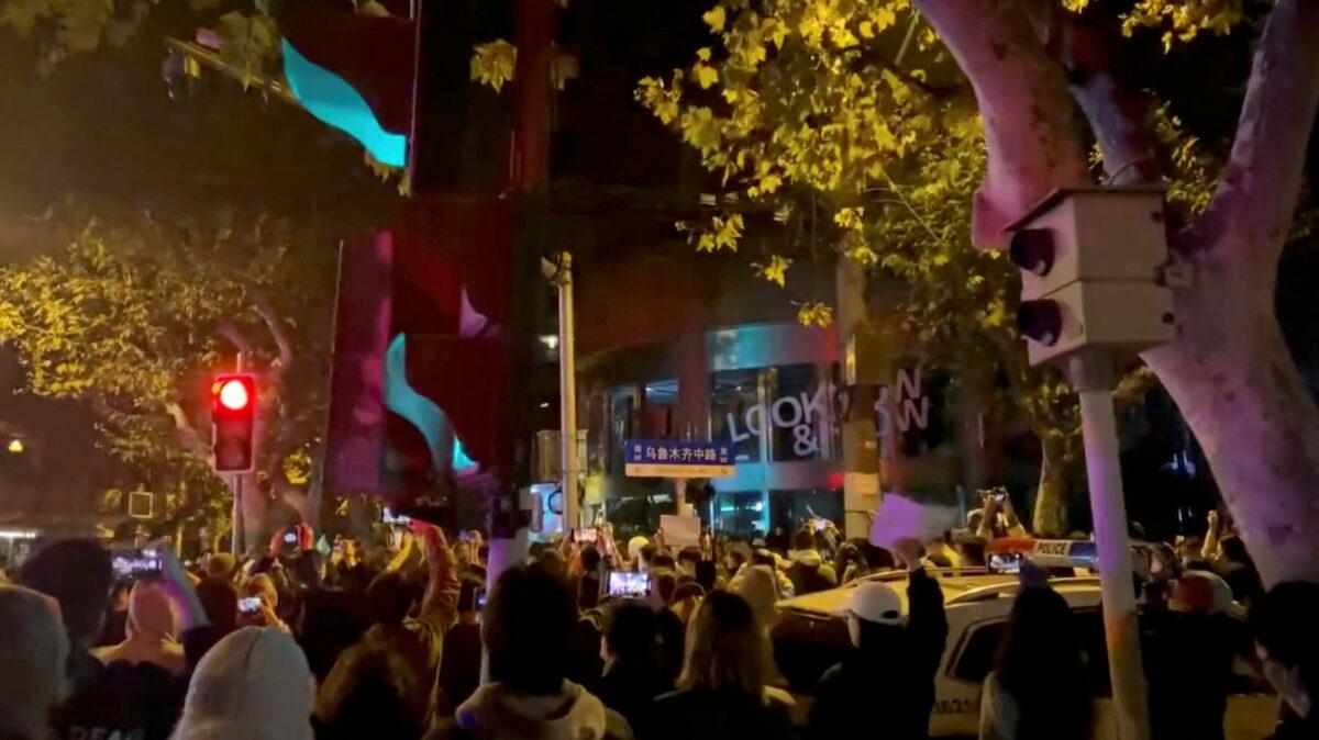 People protest against COVID-19 curbs, at the site of a candlelight vigil for victims of the Urumqi fire, in Shanghai, in a still from video released on Nov. 27, 2022. (Video obtained by Reuters)