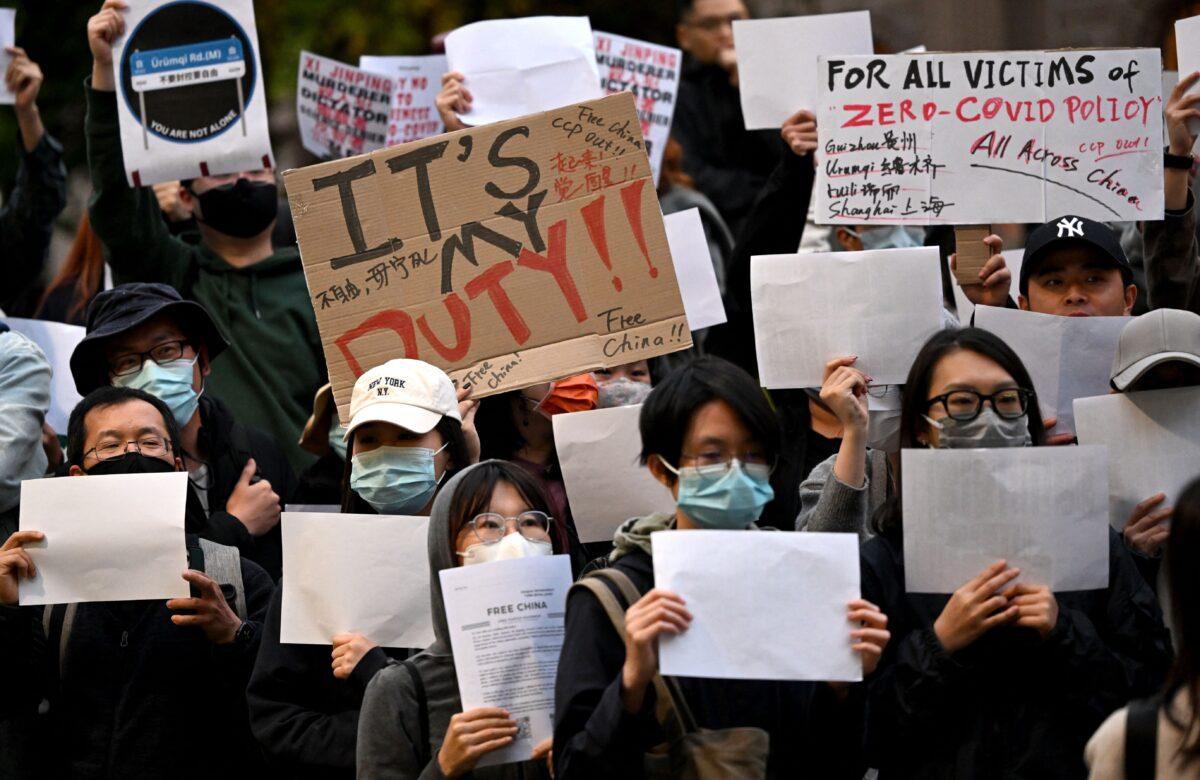 Members of the local Chinese community hold placards at a vigil in support of the protests against Beijing's zero-COVID policy taking place across China, in Melbourne on Nov. 28, 2022. (William West/AFP via Getty Images)