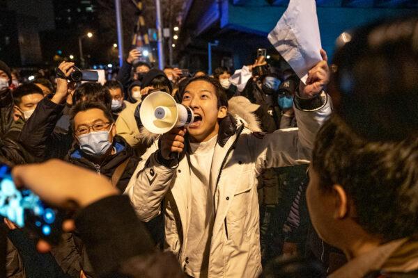 A demonstrator holds a blank sign and chants slogans during a protest in Beijing on Nov. 28, 2022. (Bloomberg via Getty Images)