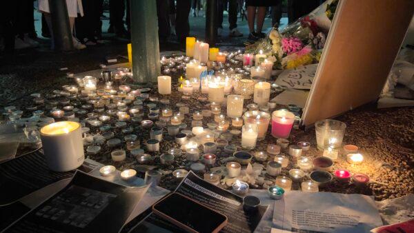 Protesters held a vigil night for the victims of the Urumqi fire incident. (Ling Xiao/The Epoch Times)