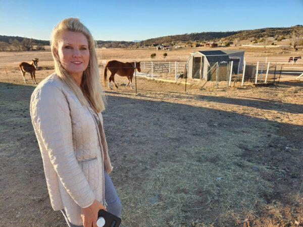 Simone Netherlands inspects recently arrived Alpine wild horses at the Salt River Wild Horse Management Group's sanctuary in Prescott, Ariz., on Nov. 30, 2022. (Allan Stein/The Epoch Times)