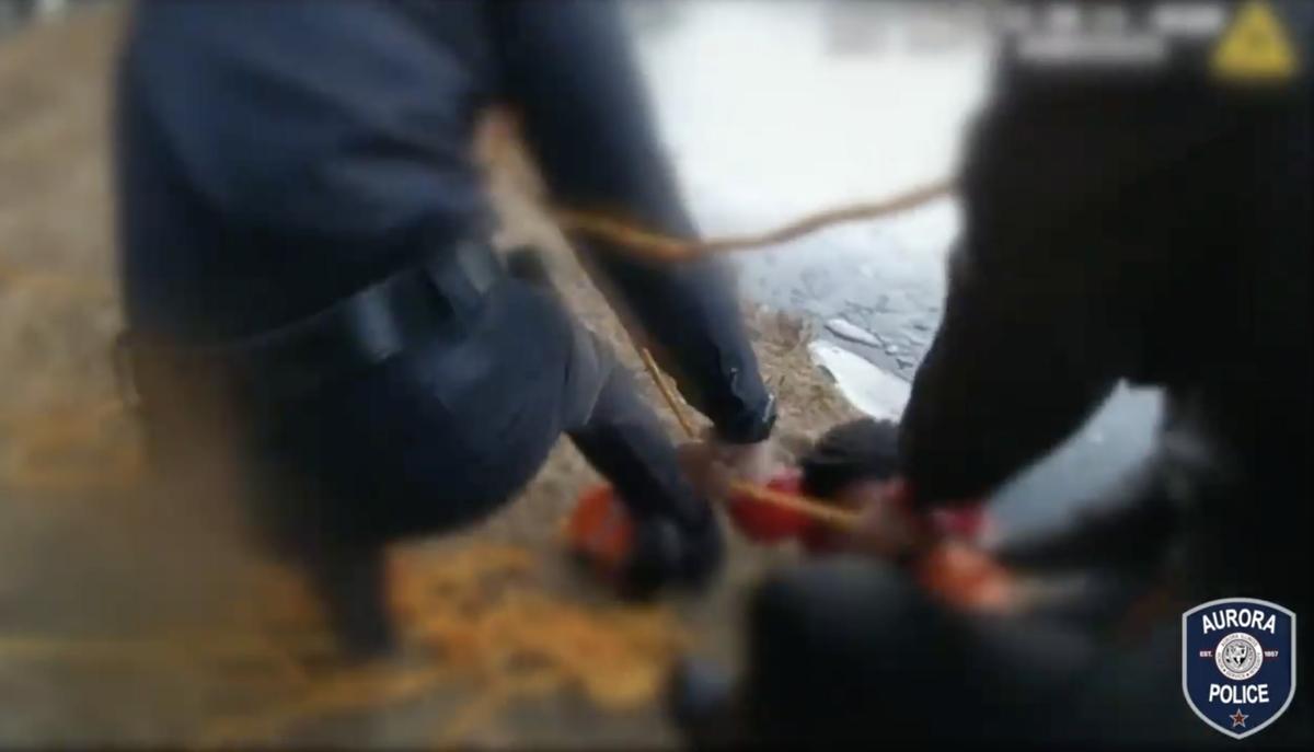 Illinois police officers attempt to rescue the boy who was stuck in the icy pond. (Courtesy of Aurora Illinois Police Department)