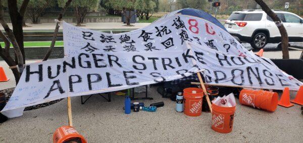 A banner calls for a response from Apple outside Apple’s headquarters on Dec. 10, 2022. (David Lam/NTD)