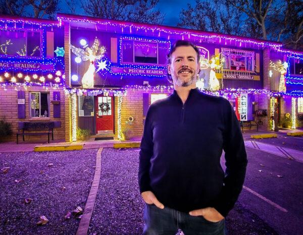 Charley Lamson, a psychic at the Center for the New Age in Sedona, Ariz., stands in front of the center at dusk on Dec. 7, 2022. (Allan Stein/The Epoch Times)