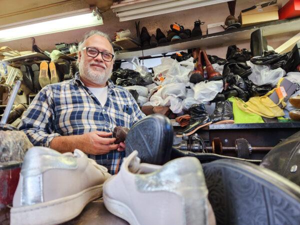 Cobbler Felipe Torres works on a pair of old leather shoes inside his shoe-shaped repair shop in Bakersfield, Calif., on Dec. 9, 2022. (Allan Stein/The Epoch Times)