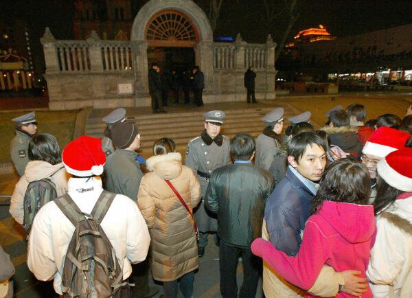 Chinese security guards together with police keep hundreds of Chinese Christian worshippers away from the Wangfujing Catholic Church in Beijing, during Christmas mass, on 25 Dec. 2003. (Goh Chai Hin/AFP via Getty Images)