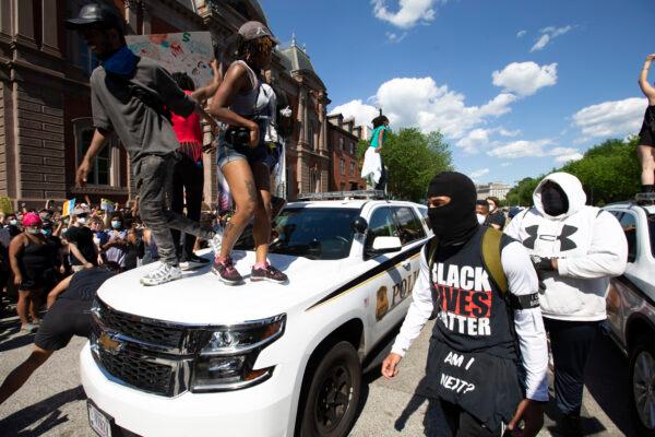 Demonstrators jump on a secret service police car outside the White House in Washington during a protest over the death of George Floyd on May 30, 2020. (Jose Luis Magana/AFP via Getty Images)