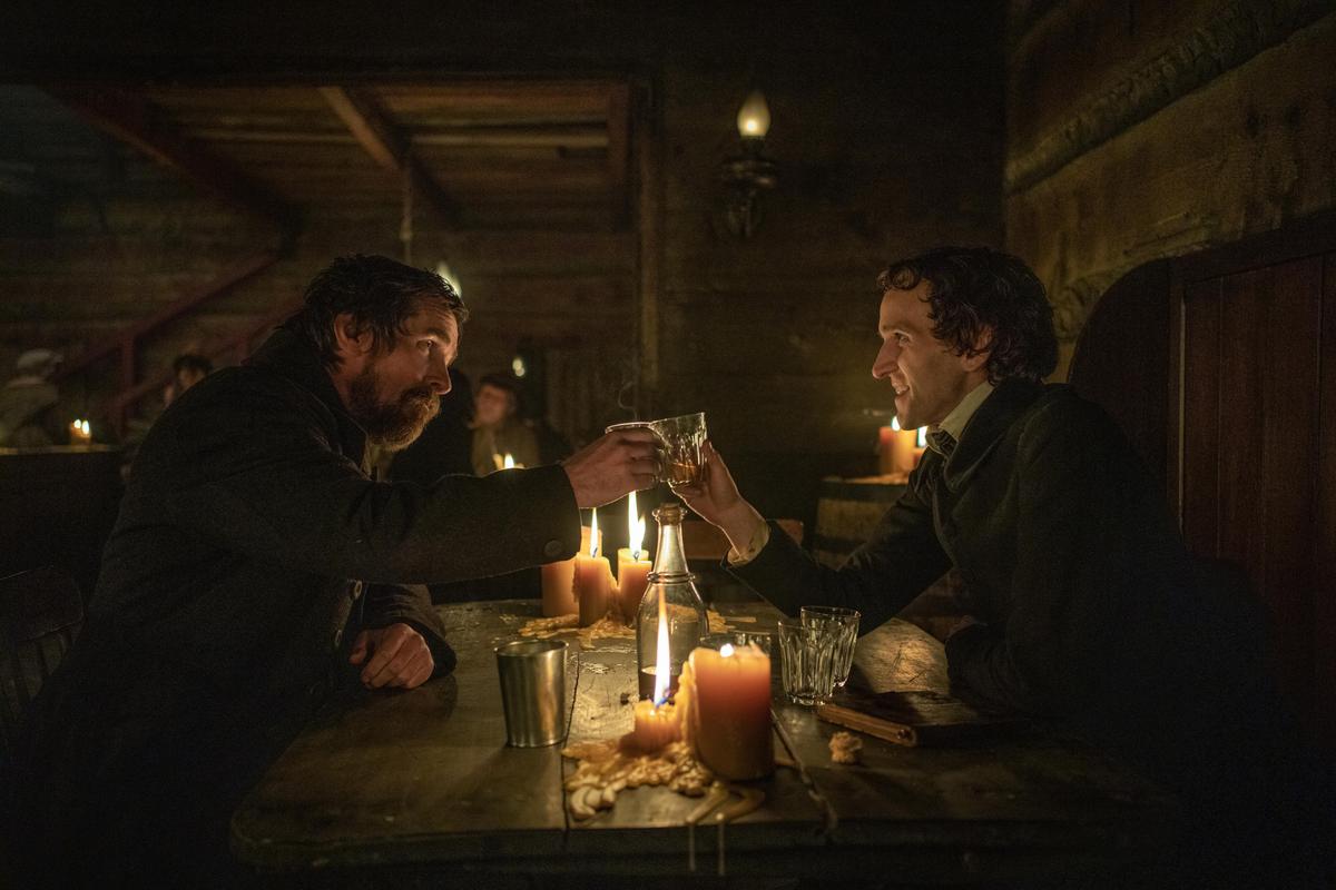 Police detective Augustus Landor (Christian Bale, L) with Cadet Fourth Classman Edgar Allan Poe (Harry Melling), in "The Pale Blue Eye." (Scott Garfield/Netflix)