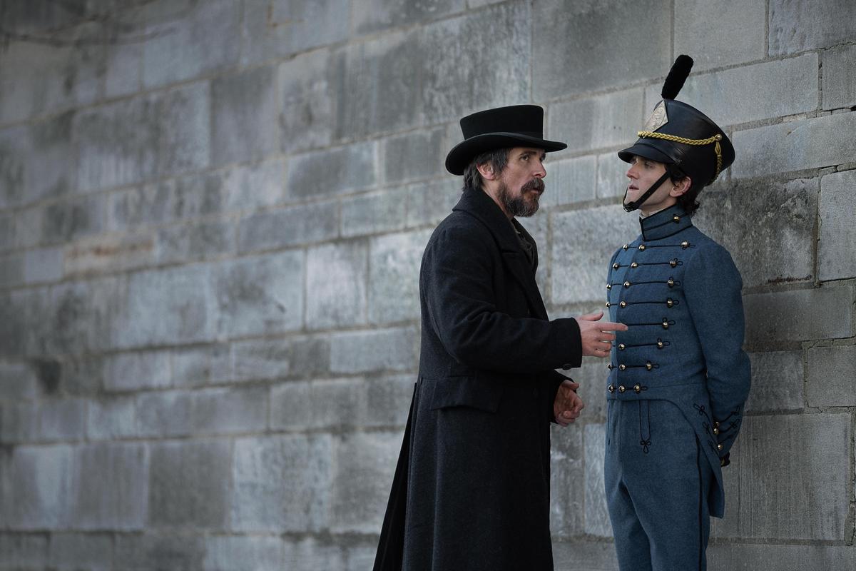 Police detective Augustus Landor (Christian Bale, L) with Cadet Fourth Classman E.A. Poe (Harry Melling), in "The Pale Blue Eye." (Scott Garfield/Netflix)
