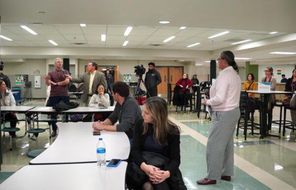 Fairfax County Public Schools superintendent Michelle Reid (R) listens as Glenn Miller (L), a father of a Langley High School student, asks a question at the school cafeteria in McLean, Va., on Jan. 10, 2023. (Terri Wu/The Epoch Times)