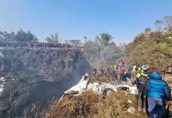 Crowds gather as rescue teams work to retrieve bodies at the crash site of an aircraft carrying 72 people in Pokhara in western Nepal on Jan. 15, 2023. (Bijay Neupane/Handout via Reuters)