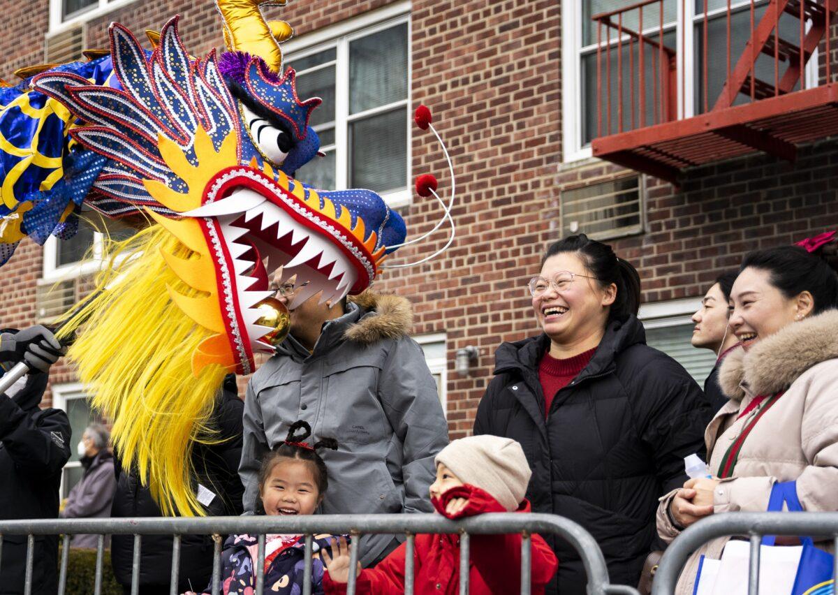 Bystanders interact with Falun Gong practitioners during the Chinese New Year parade in Flushing, N.Y., on Jan. 21, 2023. (Chung I Ho/The Epoch Times)