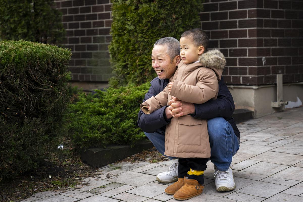 Bystanders watch Falun Gong practitioners participate in the Chinese New Year parade in Flushing, N.Y., on Jan. 21, 2023. (Chung I Ho/The Epoch Times)