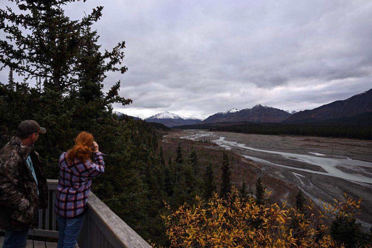 Visitors look at the Teklanika River from the Teklanika rest area at Mile 30 on the park road in Denali National Park in Denali, Alaska, on Sept. 20, 2022. (Patrick T. Fallon/AFP/Getty Images)