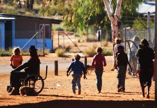 Members of the Mutitjulu Aboriginal community walk through the grounds in Mutitjulu, near Alice Springs, Australia, on July 6, 2007. (Ian Waldie/Getty Images)