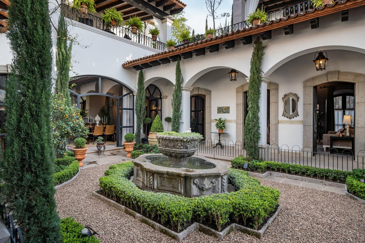 The residence’s central courtyard features fruit trees and a classic fountain. Above, covered terraces afford lovely sunset views over San Miguel De Allende. (Courtesy of Agave Sotheby's International Realty)