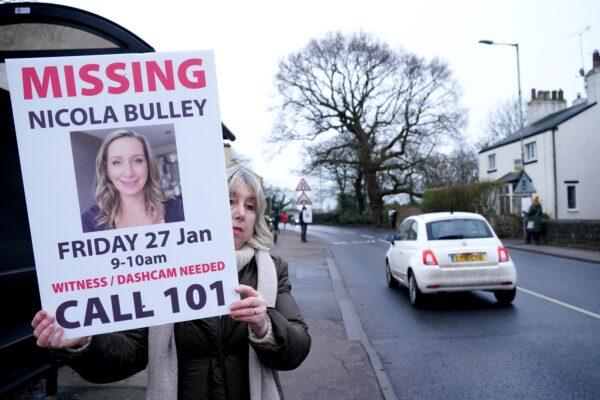 A woman holds up a placard during a search for Nicola Bulley, who went missing in Lancashire, England, on Jan. 27, 2023. (PA)