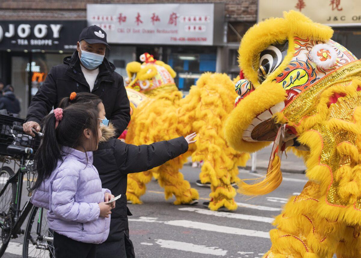 Bystanders watch Falun Gong practitioners march in a parade, in Brooklyn, N.Y., highlighting the persecution of their faith in China, on Feb. 26, 2023.(Chung I Ho/The Epoch Times)