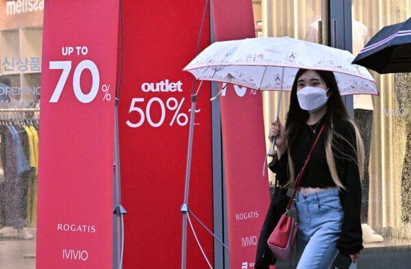 A woman walks past a sale sign at a shopping district in Seoul on July 13, 2022, after South Korea's central bank delivered a historic half-point interest rate hike to tame fast-growing inflation. (Jung Yeon-je /AFP via Getty Images)