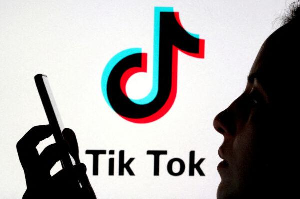 A person holds a smartphone as a TikTok logo is displayed behind in this picture illustration taken on Nov. 7, 2019. (Dado Ruvic/Reuters)