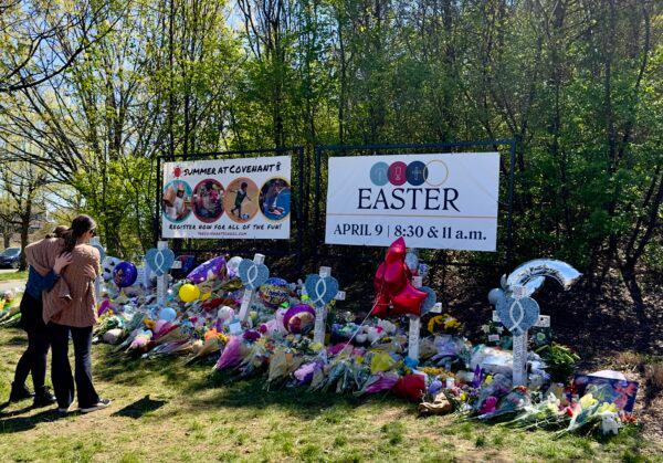 Two women comfort one another at the makeshift memorial for the six victims killed in The Covenant School shooting in Nashville, Tenn., on March 27, 2023. (Chase Smith/The Epoch Times)