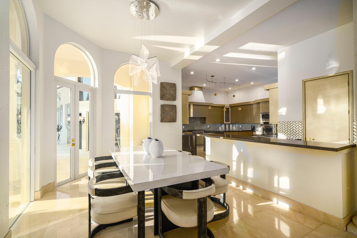 The well-equipped and spacious kitchen opens into a dining area for casual family meals, with glass doors leading out to the pool area. (Courtesy of The Carroll Group)