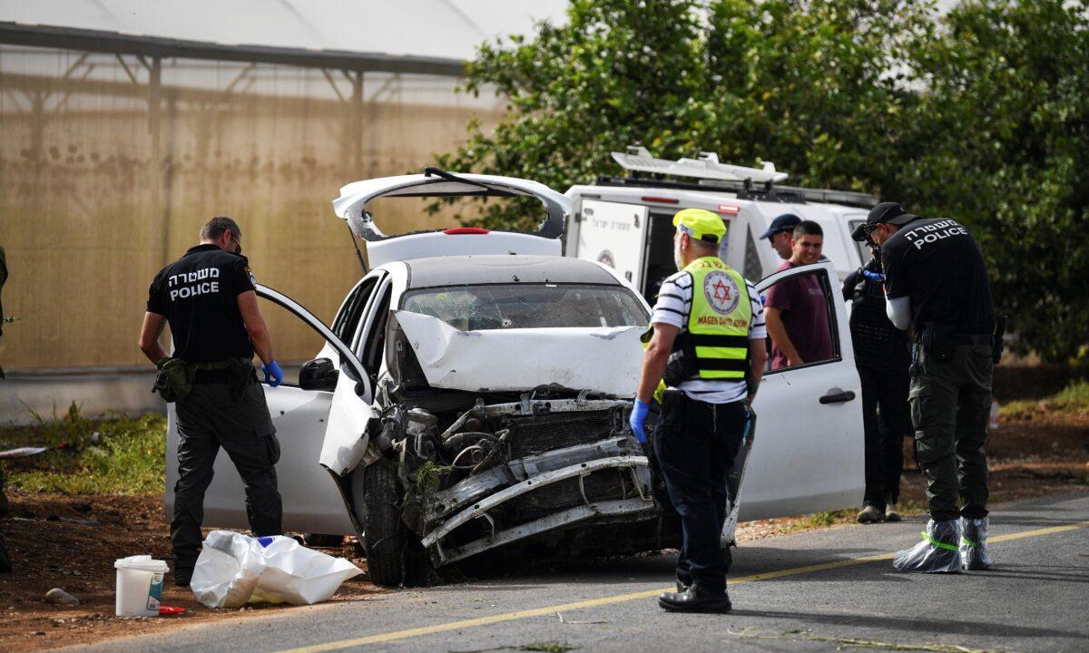 Israeli medics and policemen check a damaged car at the scene of a shooting attack, in the Jordan Valley in the West Bank on April 7, 2023. (Gil Eliyahu/Reuters)