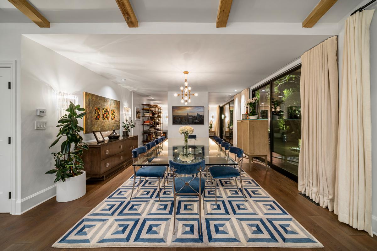 The open layout includes a formal dining room immediately adjacent to the kitchen, with an office/family room beyond. (Courtesy of One Shot Productions, TopTenRealEstateDeals.com)
