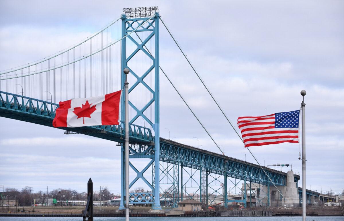 Canadian and American flags fly near the Ambassador Bridge at the Canada–U.S. border crossing in Windsor, Ont., in a file photo. (Rob Gurdebeke/The Canadian Press)