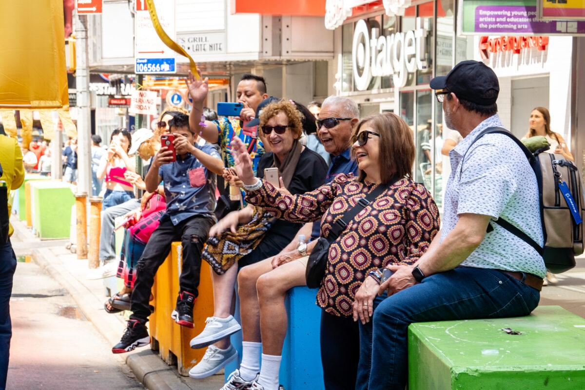 People watch as Falun Gong practitioners march in Manhattan to celebrate World Falun Dafa Day on May 12, 2023. (Samira Bouaou/The Epoch Times)