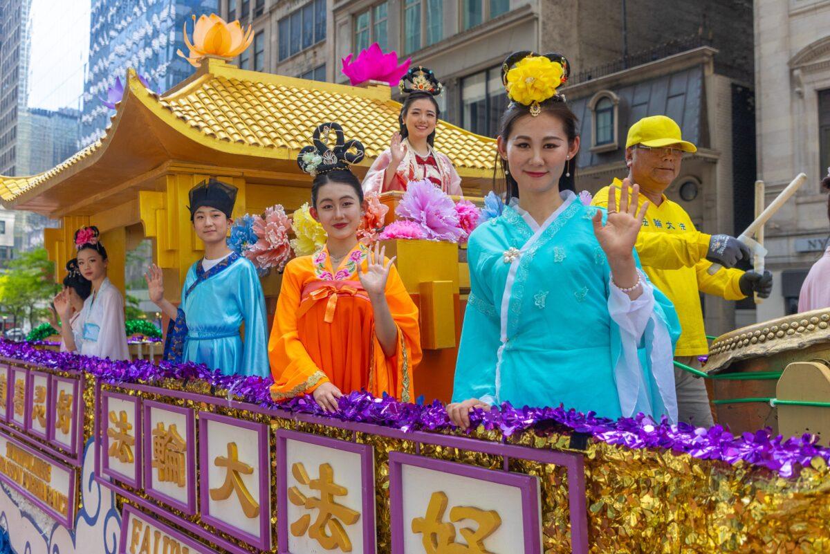 Zhang Ze (R in a yellow T-shirt) with other Falun Gong practitioners on the float he created in a World Falun Dafa Day parade in New York on May 12, 2023. (Mark Zou/The Epoch Times)