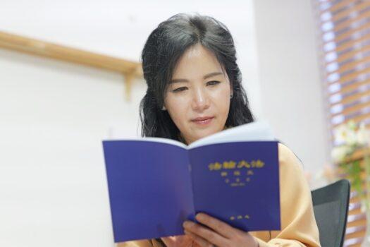 Ms. Seon Ah Son, president of the International Superqueen Superstar Agency, reading a Falun Dafa book. (Jaehyun Park/The Epoch Times)