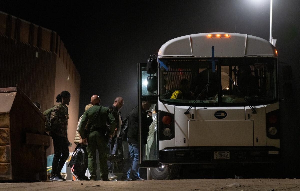 Illegal immigrants prepare to be transported by bus to Border Patrol processing facilities in Yuma, Ariz., on May 18, 2023. (John Fredricks/The Epoch Times)
