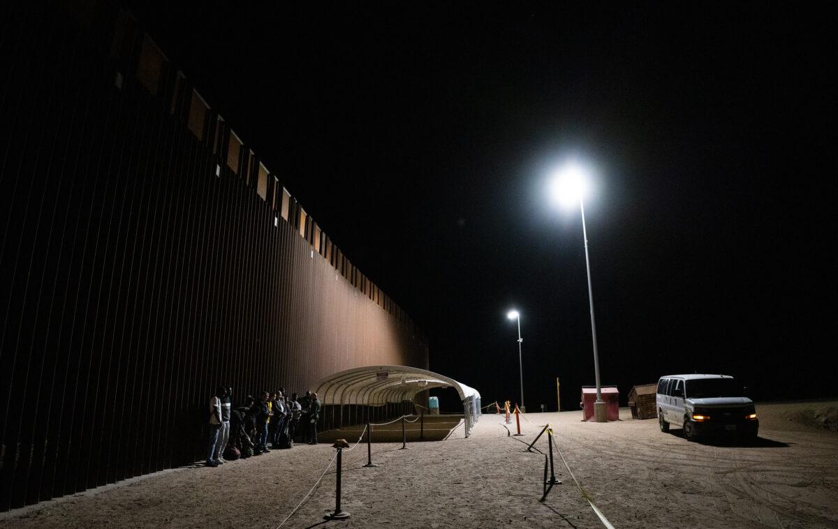 Illegal immigrants prepare to be transported by bus to processing facilities in Yuma, Ariz., on May 18, 2023. (John Fredricks/The Epoch Times)
