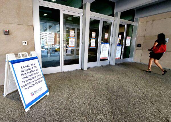 A woman walks to the front entrance of the Denver Reception Center. About 100 newly arrived asylum-seekers were registered and sent into the community on May 17, 2023. (Allan Stein/The Epoch Times)