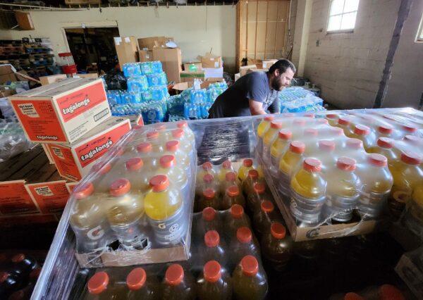 Denver Dream Center logistics manager Josh Davis goes over the inventory of donated items at a temporary supply center in downtown Denver on May 17, 2023. (Allan Stein/The Epoch Times)