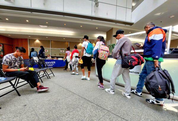 Asylum-seekers make their way to the bus station in downtown Denver on May 17, 2023. (Allan Stein/The Epoch Times)