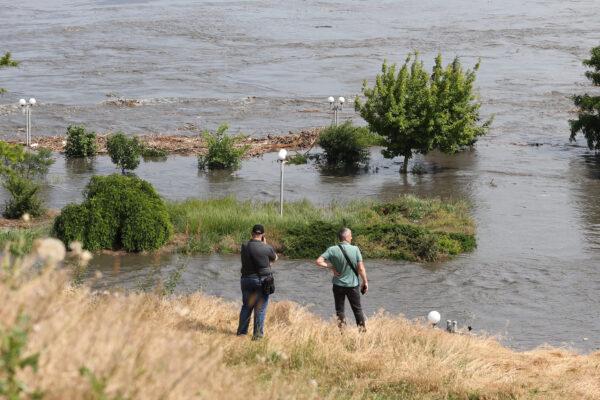 Local residents look at a partially flooded area of Kherson, Ukraine, on June 6, 2023, following damage at the Kakhovka HPP dam. (STRINGER/AFP via Getty Images)