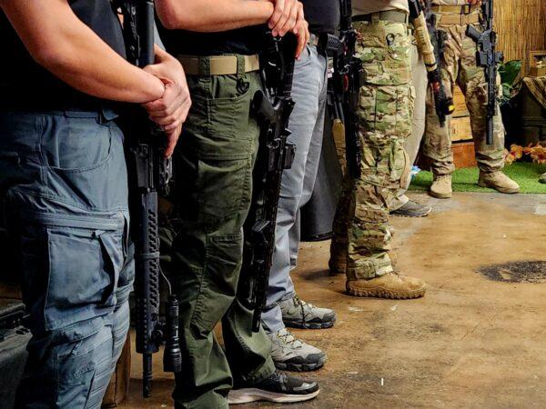 Students carrying AR-15 semiautomatic rifles keep them pointed in the safe down position on June 3, 2023. (Allan Stein/The Epoch Times)