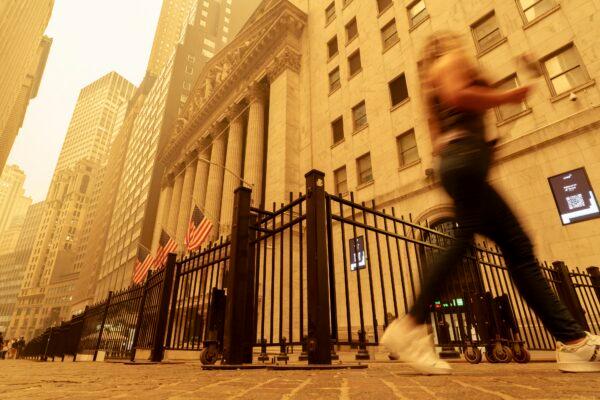A pedestrian walks past the smoke- and haze-shrouded New York Stock Exchange building on June 7, 2023. (J. David Ake/AP Photo)