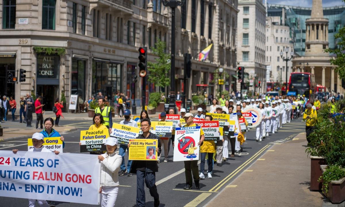 Hu Xuanming (2nd row, R), whose mother is imprisoned in China, marching in a rally commemorating the 24th anniversary of the Chinese regime's ongoing persecution of Falun Gong, in London, on July 15, 2023. (Yanning Qi/The Epoch Times)